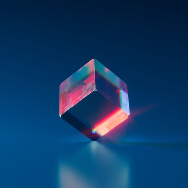 Image of a transparent cube reflecting some colors and balanced at one end